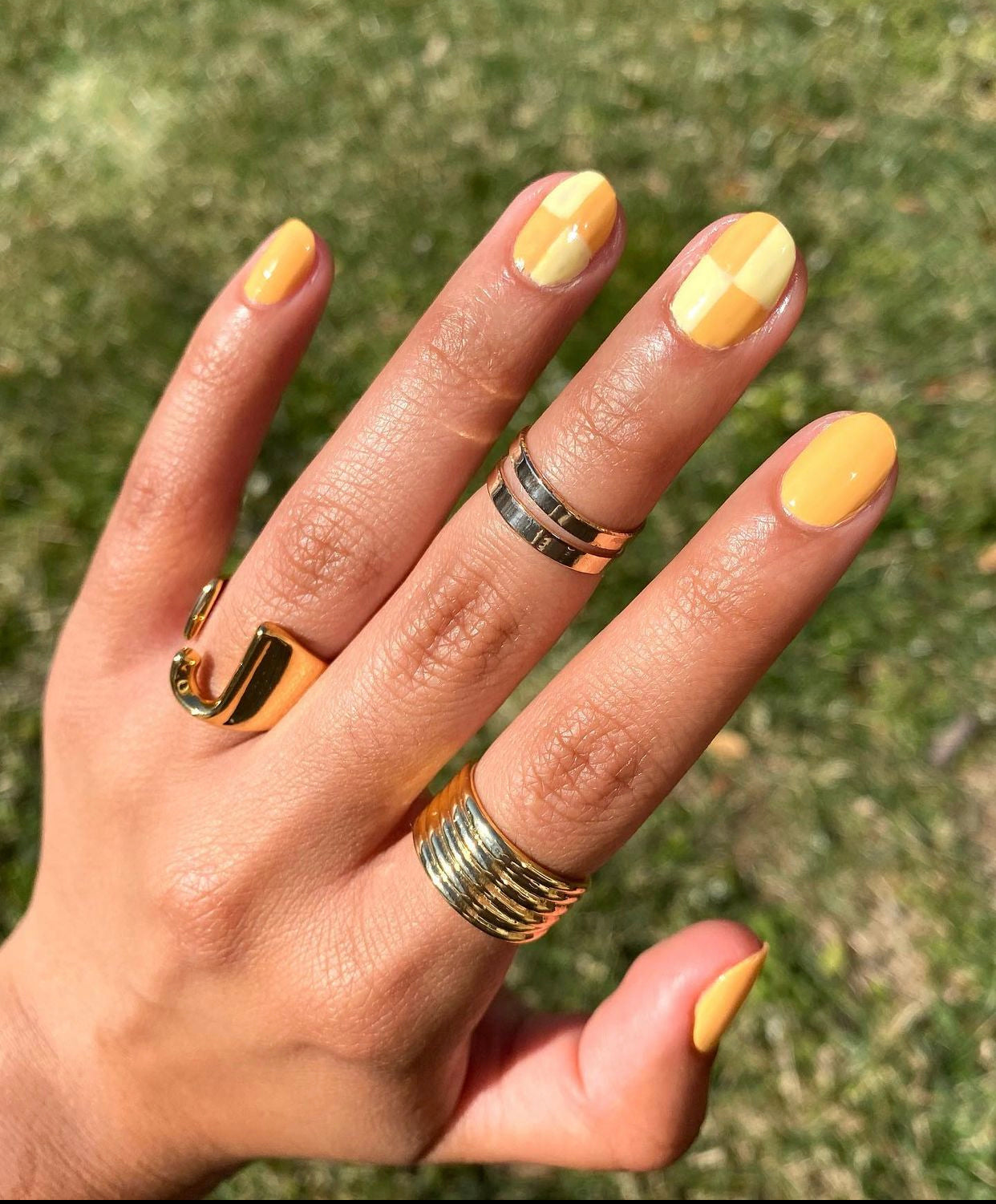 Yellow checkerboard nail design.